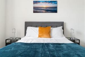1 cama con almohada naranja y 2 mesitas de noche en Corporate Housing by MGM, en West Dundee