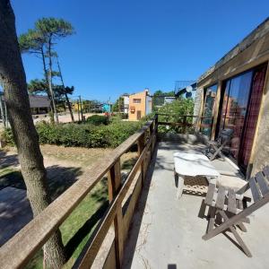 eine Terrasse mit 2 Stühlen und einem Tisch auf einem Zaun in der Unterkunft Posada Mar Azul con Jacuzzi in Punta Del Diablo