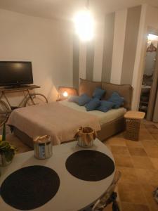 a living room with a bed with a table and a tv at La casa di Noah in Montecatini Terme