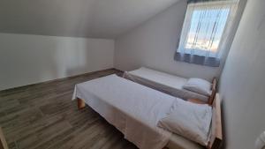 Apartment Diana - Novalja في نوفاليا: غرفة نوم صغيرة بسريرين ونافذة