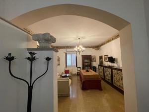 un arco che conduce a un soggiorno con letto di Dimora Teodolinda Centro Storico Marsala a Marsala