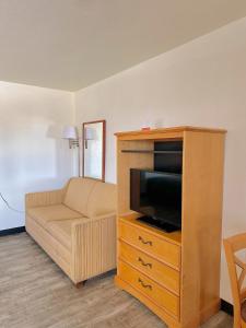 a living room with a entertainment center with a tv and a couch at Econo Lodge Lordsburg I-10 in Lordsburg