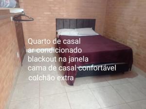 1 dormitorio con 1 cama en una pared de ladrillo en GV Apartamentos-2qt-area central nobre- ar cond- en Governador Valadares