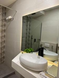 a bathroom with a white sink and a mirror at Numdor Apartments By The Bond in Port Harcourt