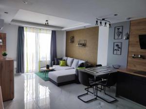 ein Wohnzimmer mit einem Sofa und einem Tisch in der Unterkunft Apartman Aranyhal City in Sárvár