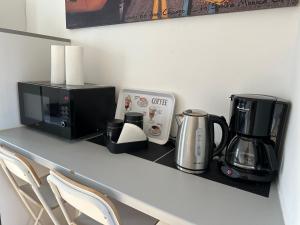 a counter with a coffee maker and a microwave at L'Escale des Weppes, appartement 40m2 in Haubourdin