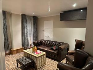 a living room with a leather couch and chairs at Flat In London's Primrose Hill in London