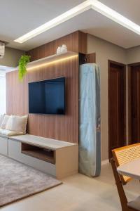 a living room with a tv and a large refrigerator at 1403 - Flat Excelente em São Luís in São Luís