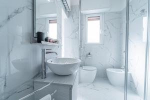 a white bathroom with a tub and a sink at BandeNereSuite Attico in Milan +22 photos