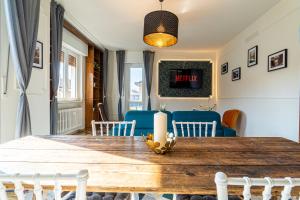 BandeNereSuite Attico في ميلانو: غرفة طعام مع طاولة خشبية وكراسي زرقاء