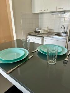 een keuken met twee borden en glazen op een aanrecht bij Charmant studio tours nord in Tours