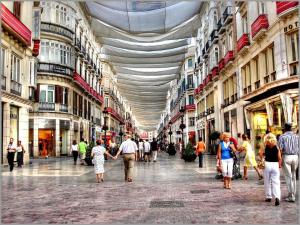 a group of people walking through a shopping mall at Suites Larios in Málaga