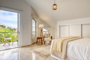 ein Schlafzimmer mit einem Bett und einem Balkon in der Unterkunft Por do Sol, a Home in Madeira in Ponta do Sol