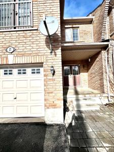 a brick house with a garage and a satellite at Bellhaven Beautiful Home in Brampton