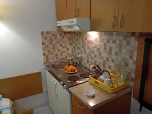 a kitchen with a sink and a bowl of oranges at Vila Centar in Trebinje