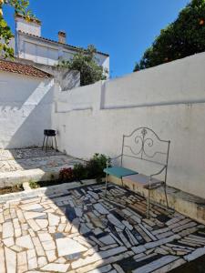 a bench sitting on a stone floor next to a wall at Casa Gil Vicente in Évora
