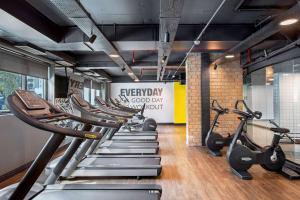 a gym with a row of treadmills and ellipticals at Suíte 5 estrelas Hotel Av Ibirapuera 2534 Moema - 1 in Sao Paulo