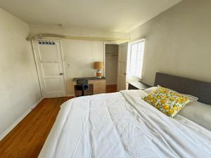 a bedroom with a white bed with a pillow on it at Cozy Home in Prime Location in Monterey Park