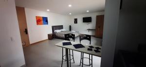 a room with a bed and a table and chairs at Confortable Aparta Loft 903 Aiana Verde in Medellín