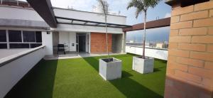 a balcony with green grass and palm trees on a building at Confortable Aparta Loft 903 Aiana Verde in Medellín