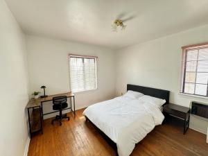 a bedroom with a bed and a desk and windows at Cozy Home in Prime Location in Monterey Park