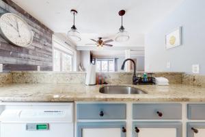 a kitchen with a sink and a clock on the wall at Ascutney Retreat in Brownsville +38 photos