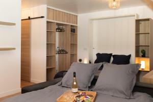 a living room with a bed and a bottle of wine at Le CinéRêve l 20' Paris l Netflix l Fibre l Parking in Boissy-Saint-Léger