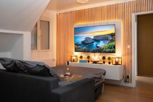 a living room with a couch and a painting on the wall at Le CinéRêve l 20' Paris l Netflix l Fibre l Parking in Boissy-Saint-Léger +26 photos
