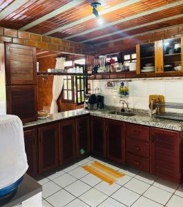 a kitchen with wooden cabinets and a sink at Casa de Campo em Gravatá super aconhegante in Gravatá