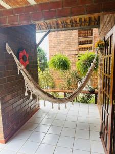 a hammock in a room with a brick wall at Casa de Campo em Gravatá super aconhegante in Gravatá