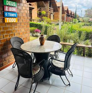 een terrastafel en stoelen met een vaas erop bij Casa de Campo em Gravatá super aconhegante in Gravatá