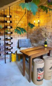 a wooden picnic table with a wall of wine bottles at Pousada Boutique das Pedras in Moeda