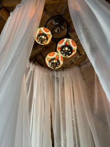 żyrandol i białe zasłony na suficie w obiekcie Akasha suites w mieście Doradal