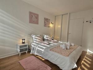 ein Schlafzimmer mit einem großen Bett mit einem Teddybär darauf in der Unterkunft Le Bonheur Charmant *Disney*Paris*RER A* in Bussy-Saint-Georges