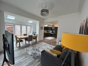 ein Wohnzimmer mit einem Sofa und einem Esszimmer in der Unterkunft Gosforth Haven: Timeless Charm! in Gosforth