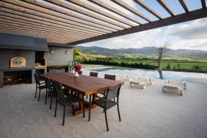 a patio with a wooden table and chairs and a pool at Herdade do Lameiro - Turismo Rural in Ribeira Grande