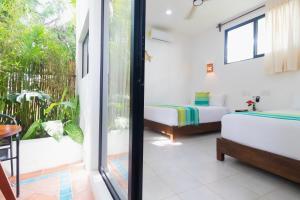 a bedroom with a bed and a balcony at Maison Bacalar in Bacalar