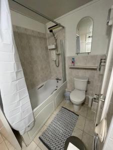 a bathroom with a tub and a toilet and a sink at Canterbury Escapes 2 bedrooms in Kent