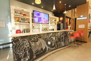 a restaurant with a bar with red chairs at Ajax Hoteis in Colatina