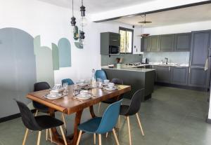 una cucina e una sala da pranzo con tavolo e sedie in legno di Villa T4 avec piscine, 6 à 8 personnes a Schœlcher