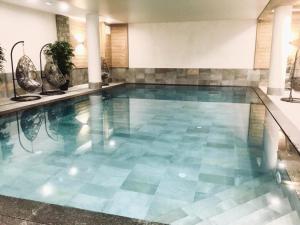 a swimming pool with a blue tile floor at Résidence Lodge Des Neiges C - 3 Pièces pour 6 Personnes 291 in Tignes