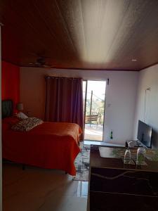 a bedroom with a bed and a television and a window at Cabanas Zamoray 