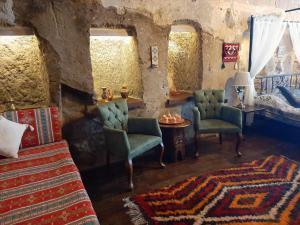 a bedroom with a bed and chairs and a table at Mayaoglu Konagi Hotel in Guzelyurt