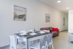 una sala da pranzo con tavolo, sedie e divano di Spacious Brand New Apartment 3 Bdr 2Bth Bugibba HC12 a San Pawl il-Baħar