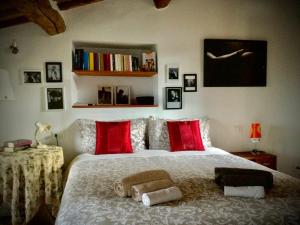 um quarto com uma cama grande e almofadas vermelhas em La Casa di Zoe al borgo em Perugia