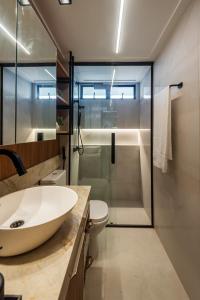 a bathroom with a white sink and a shower at 1403 - Flat Excelente em São Luís in São Luís