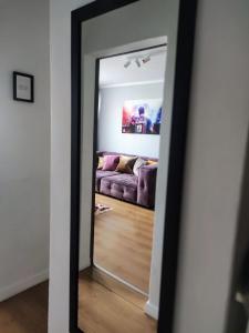 einen Spiegel im Wohnzimmer mit Sofa in der Unterkunft Skyline Panorama Residence Warsaw in Warschau