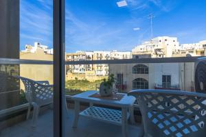 balcone con tavolo, sedie e vista sulla città di Spacious Brand New Apartment 3 Bdr 2Bth Bugibba HC12 a San Pawl il-Baħar