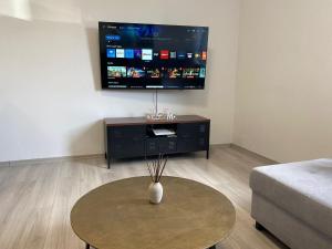 a living room with a table and a flat screen tv at NES 1 - nähe Freiheitshalle Hof in Hof