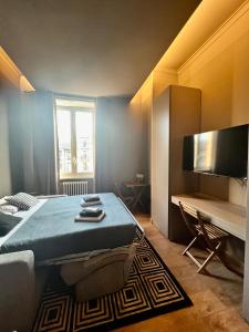 ミラノにあるNEW LUXURY STUNNING BILO APARTMENT IN THE HEART OF MILAN MOSCOVAのベッドルーム(ベッド1台、テレビ、ソファ付)